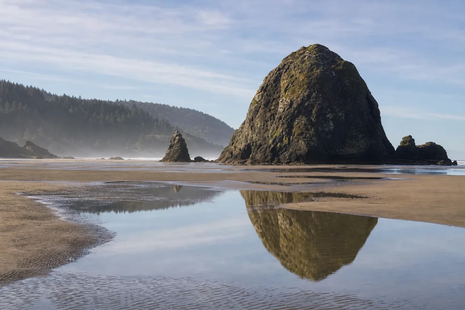 Haystack Rock rising from the sand at Cannon Beach on the Oregon Coast, a day trip from Portland
