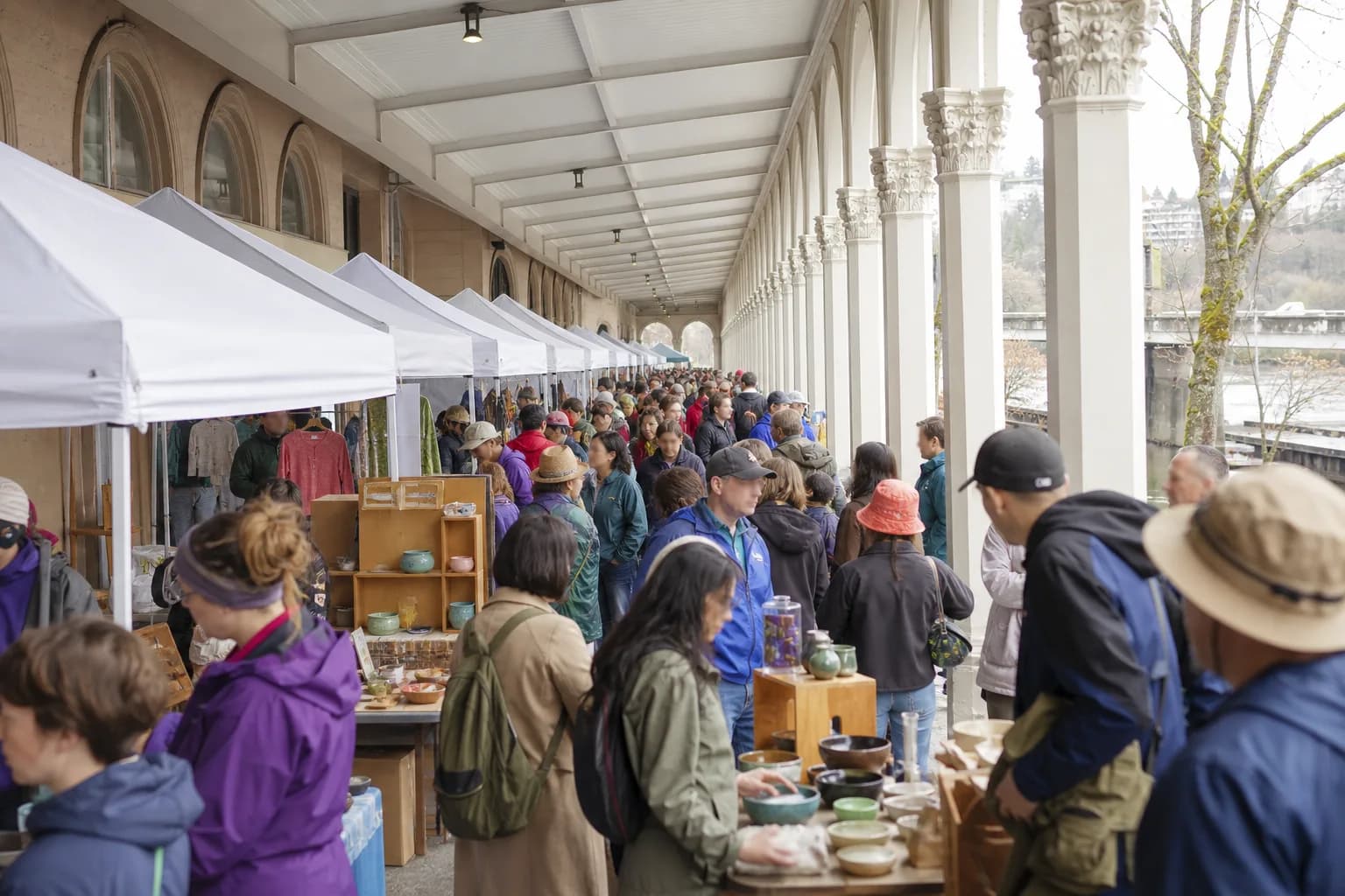Shoppers browsing artisan tents at Portland Saturday Market on the downtown waterfront