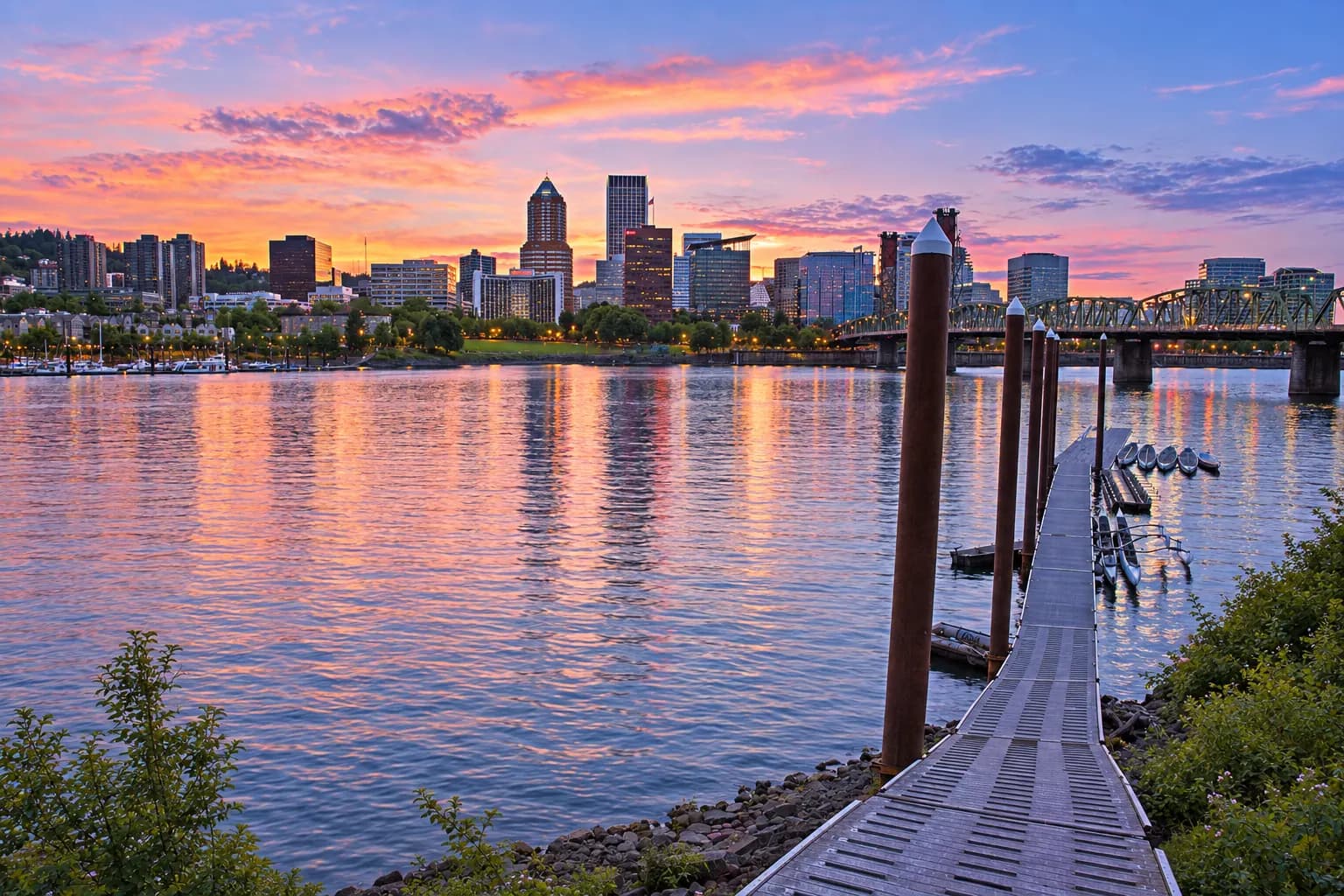 Downtown Portland skyline and the Hawthorne Bridge across the Willamette River from the Eastbank Esplanade at dusk
