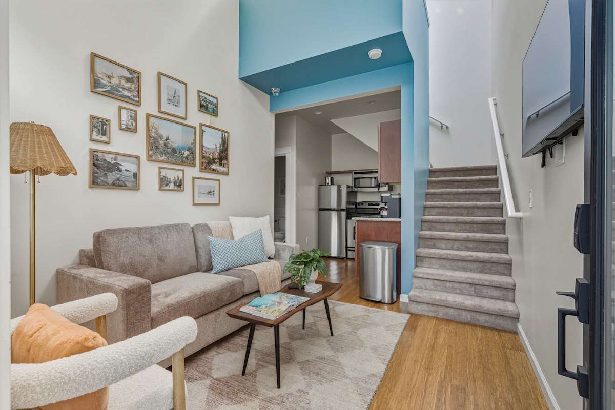 Living room with sofa and loft stairs.
