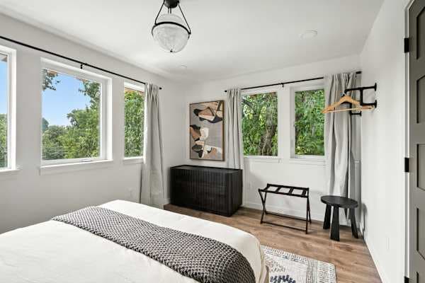 Bedroom 1 with queen bed and bright windows.